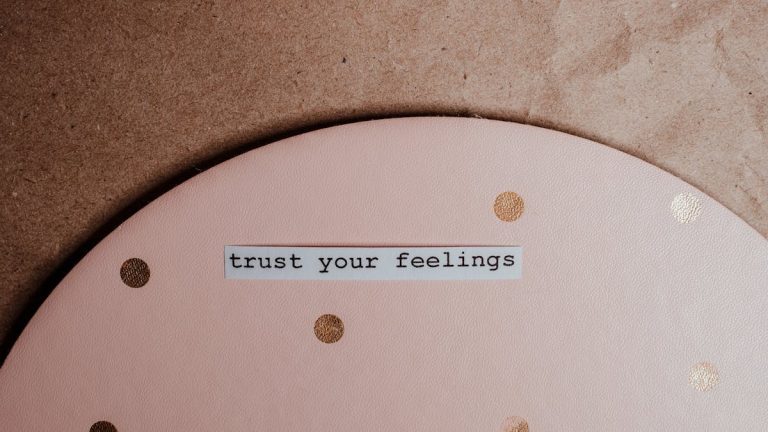 Close-up of a motivational message 'trust your feelings' on a pink polka dot and brown background.
