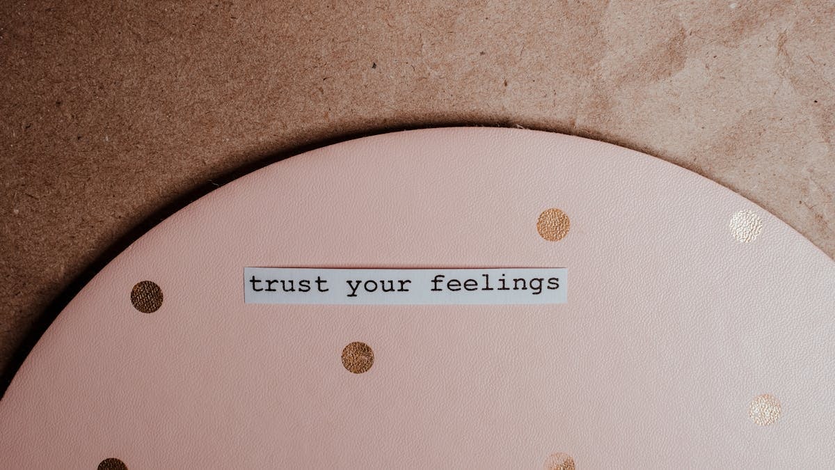 Close-up of a motivational message 'trust your feelings' on a pink polka dot and brown background.